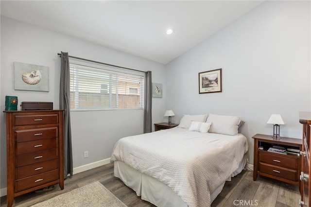 bedroom with vaulted ceiling and dark wood-type flooring