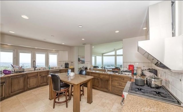 kitchen with sink, decorative backsplash, and stainless steel gas cooktop