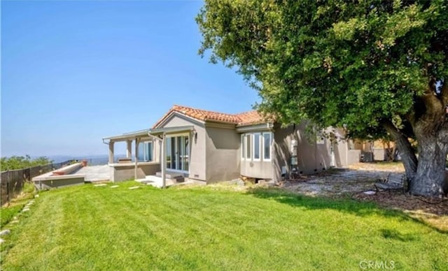 back of house featuring a patio area and a lawn