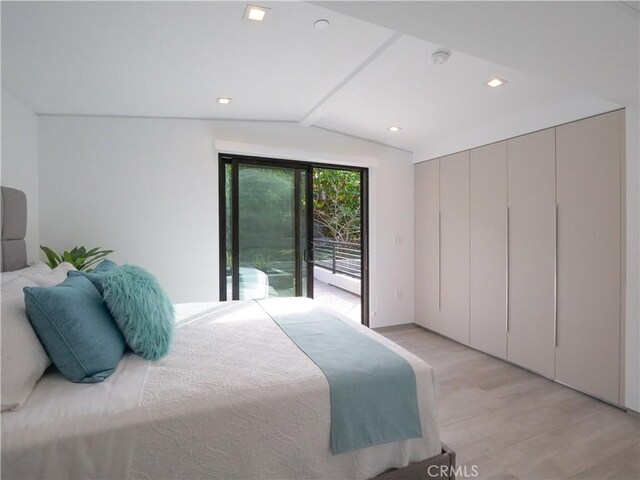 bedroom featuring lofted ceiling, access to exterior, and light hardwood / wood-style floors