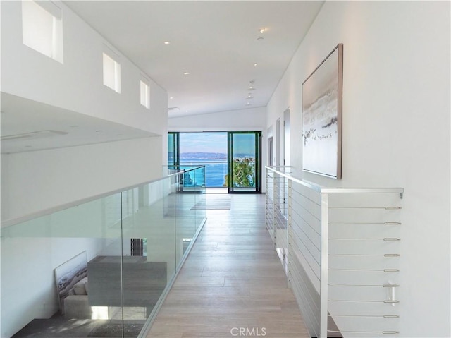 hall featuring vaulted ceiling and light hardwood / wood-style floors