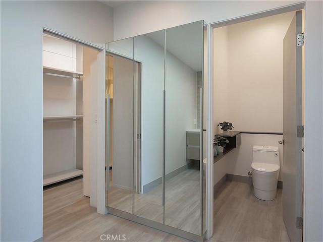 bathroom featuring wood-type flooring and toilet