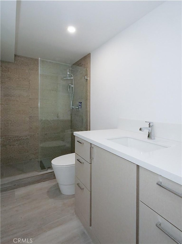 bathroom featuring vanity, toilet, and tiled shower