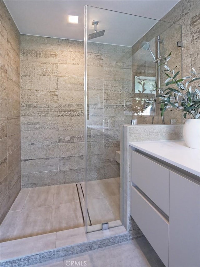 bathroom with vanity and a tile shower