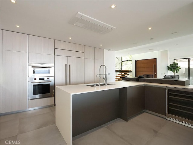 kitchen with wine cooler, double oven, and sink