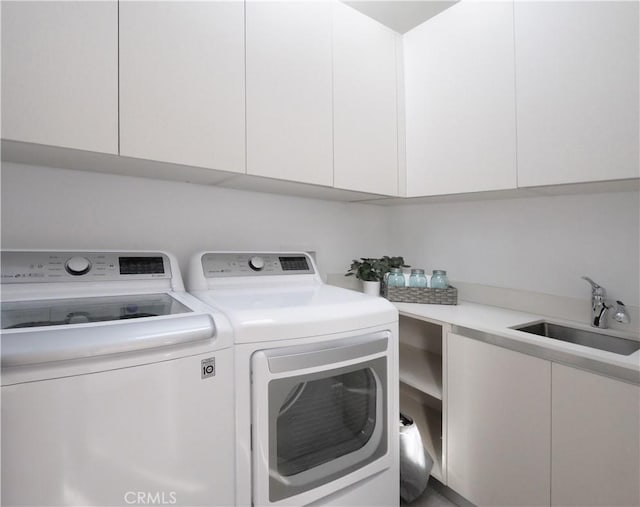 laundry room featuring cabinets, sink, and washer and clothes dryer