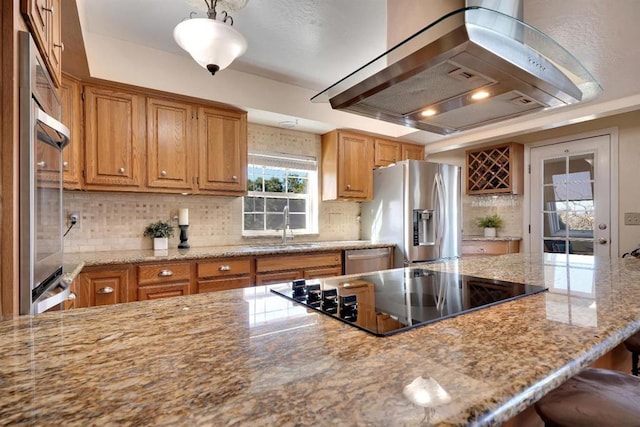 kitchen featuring sink, island range hood, hanging light fixtures, appliances with stainless steel finishes, and a kitchen breakfast bar