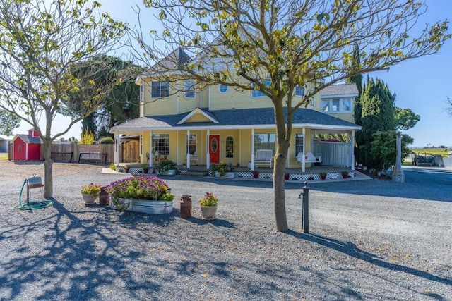 victorian house with a porch and a storage shed