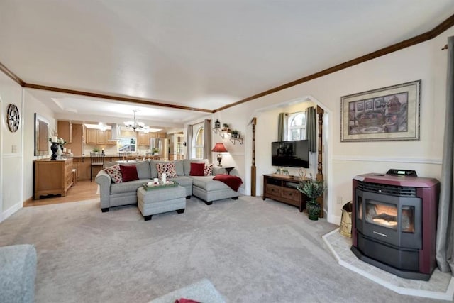 carpeted living room featuring an inviting chandelier, ornamental molding, and a wood stove