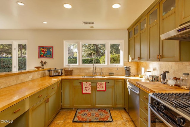 kitchen featuring appliances with stainless steel finishes, wooden counters, sink, and decorative backsplash