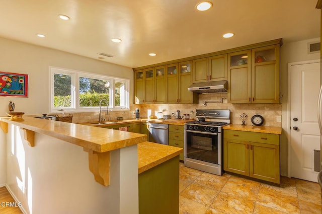 kitchen featuring sink, a kitchen breakfast bar, gas stove, wood counters, and stainless steel dishwasher