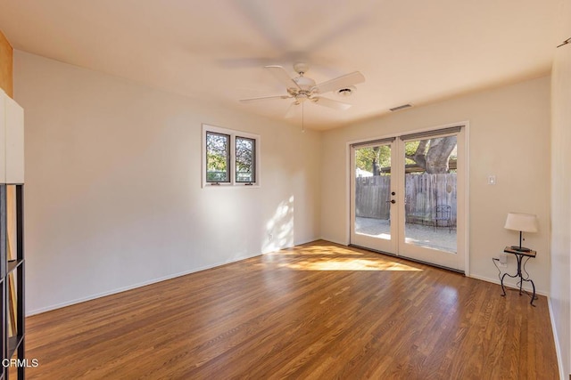 empty room with wood-type flooring, french doors, and ceiling fan