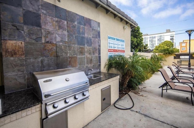 view of patio featuring an outdoor kitchen, sink, and grilling area