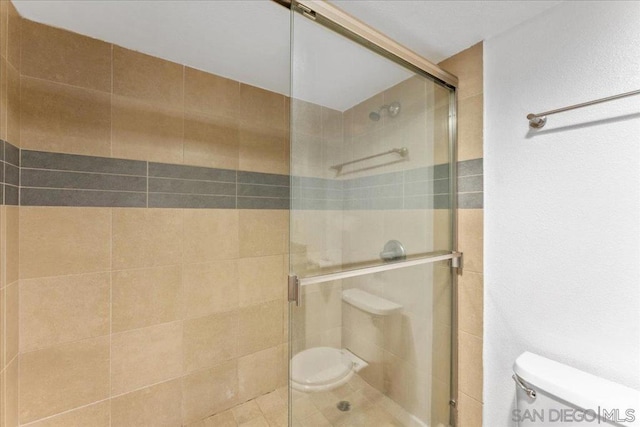 bathroom with toilet and an enclosed shower