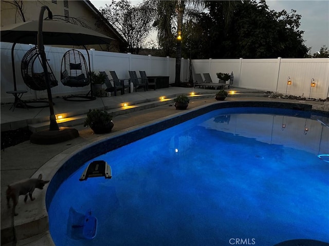 pool at dusk with a patio