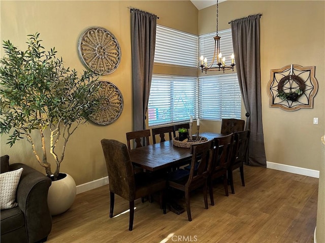 dining space featuring hardwood / wood-style floors and a notable chandelier