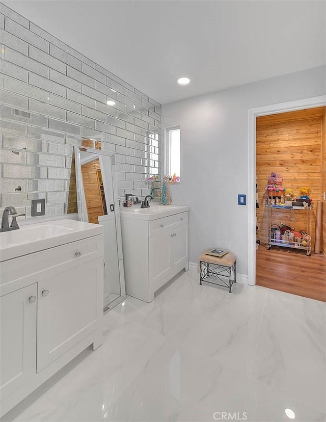 washroom featuring sink and wood walls