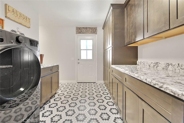 clothes washing area featuring cabinets and washer / clothes dryer