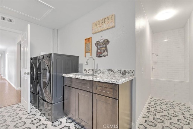 laundry area featuring cabinets, washer and clothes dryer, and sink