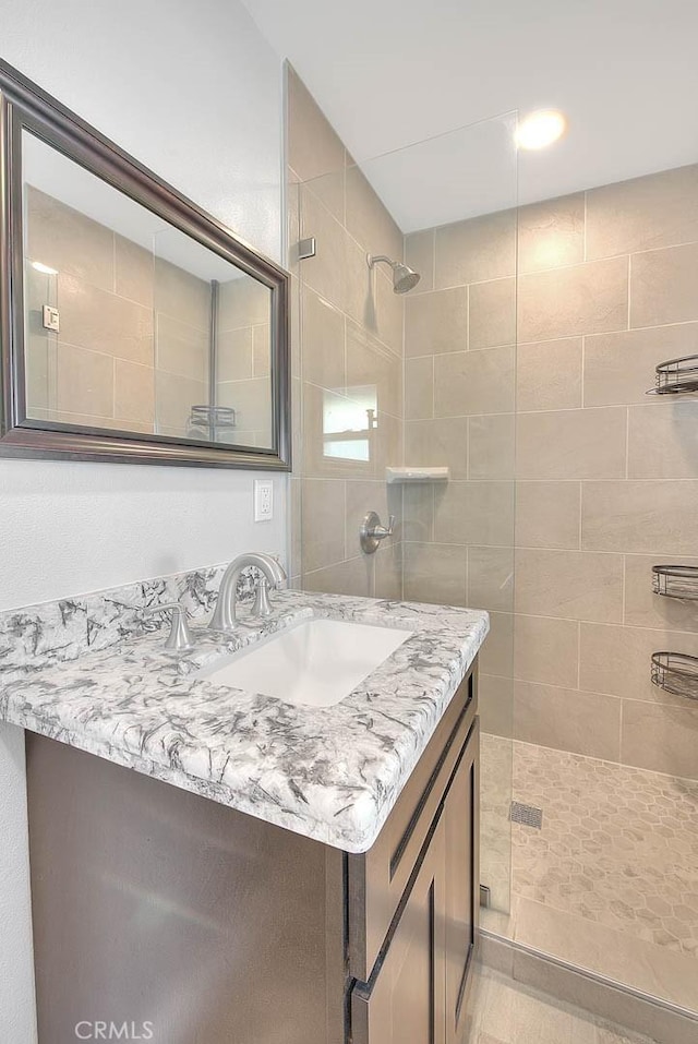 bathroom with vanity and a tile shower