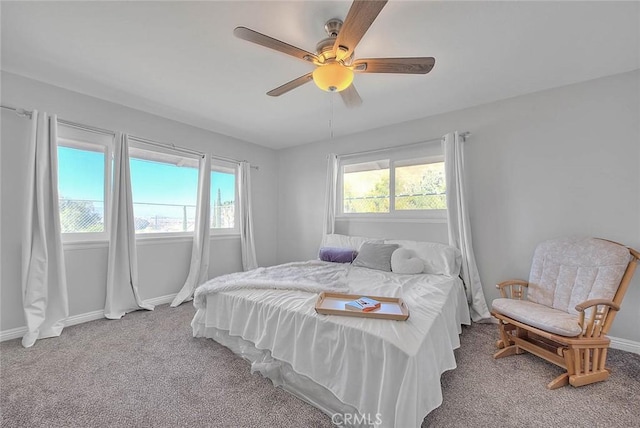 carpeted bedroom with ceiling fan and multiple windows