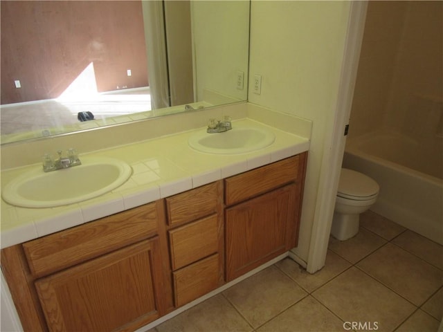 full bathroom featuring a sink, toilet, double vanity, and tile patterned flooring