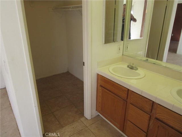 bathroom featuring double vanity, tile patterned floors, and a sink