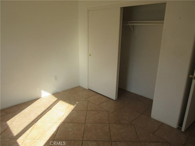 unfurnished bedroom featuring a closet and tile patterned flooring