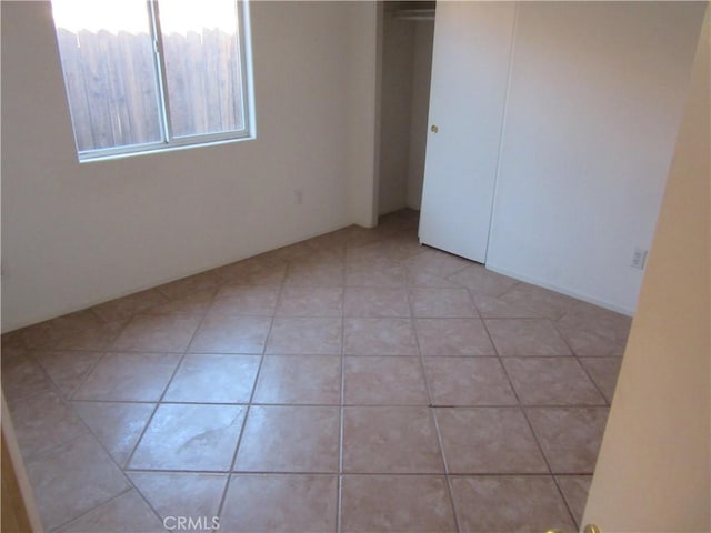 unfurnished bedroom with a closet and light tile patterned flooring