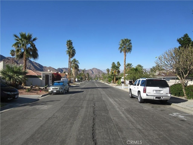 view of street with sidewalks, curbs, and a mountain view