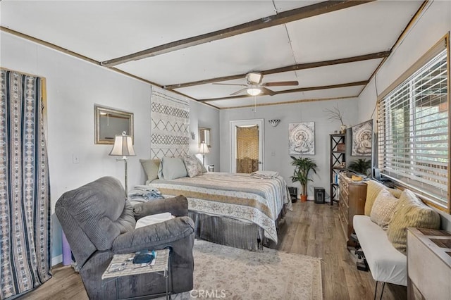 bedroom with beamed ceiling, ceiling fan, and light wood-type flooring