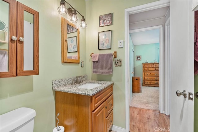 bathroom featuring hardwood / wood-style flooring, vanity, and toilet