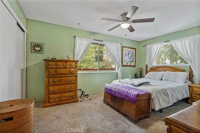 carpeted bedroom featuring ceiling fan, a closet, and multiple windows