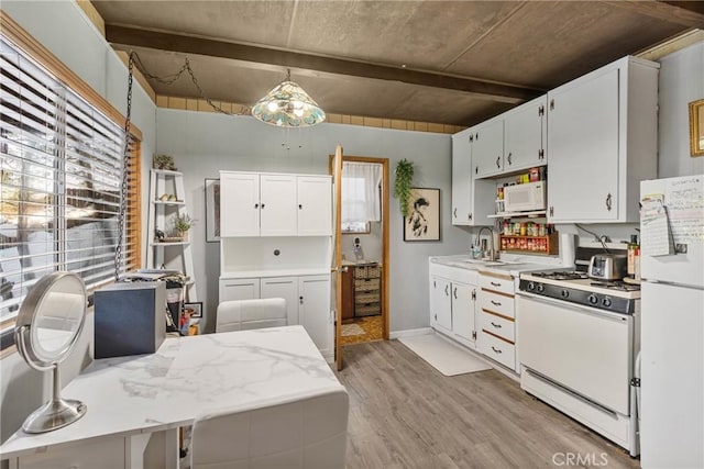 kitchen with pendant lighting, white appliances, white cabinetry, and light hardwood / wood-style flooring