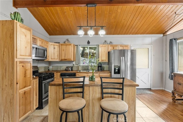 kitchen with stainless steel appliances, hanging light fixtures, vaulted ceiling with beams, and light brown cabinets