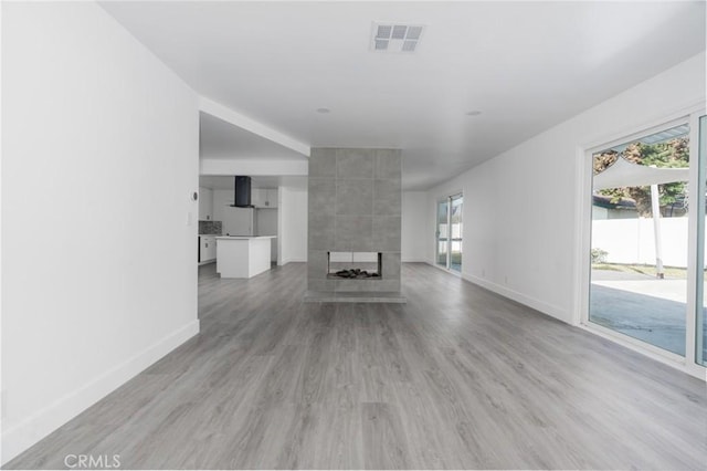 unfurnished living room with a fireplace and light hardwood / wood-style flooring