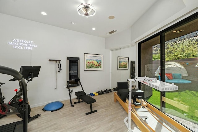 exercise room featuring light wood-type flooring