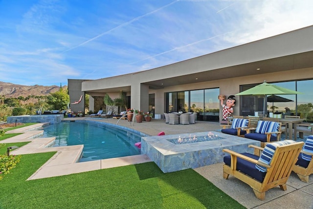 view of pool with a mountain view, a patio, pool water feature, and an outdoor fire pit