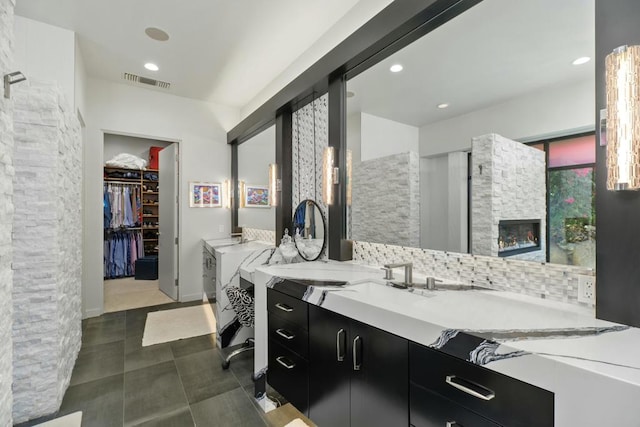 bathroom featuring vanity, backsplash, and a fireplace