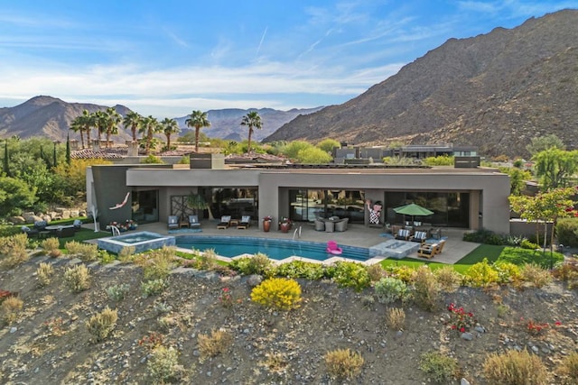 view of swimming pool featuring a mountain view, a patio, and an in ground hot tub