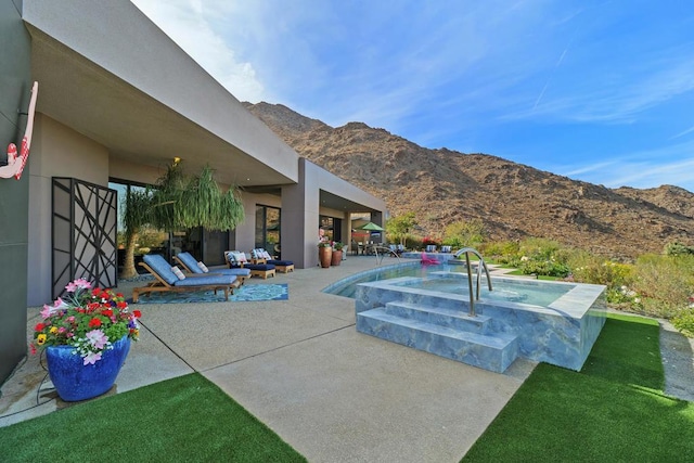 view of swimming pool with a patio and a mountain view