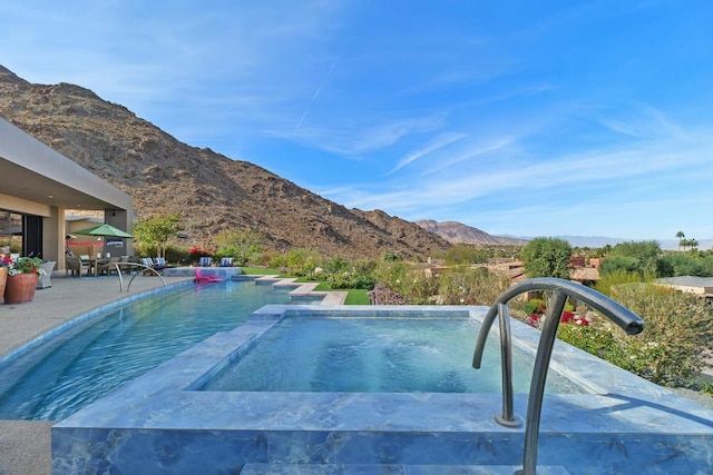 view of pool with a mountain view and a patio