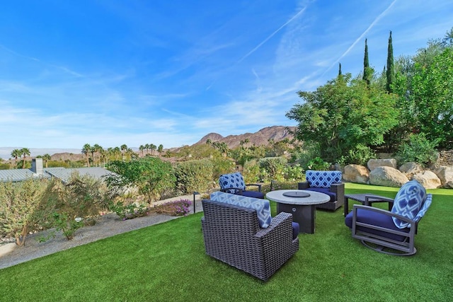 view of yard featuring a mountain view and an outdoor fire pit