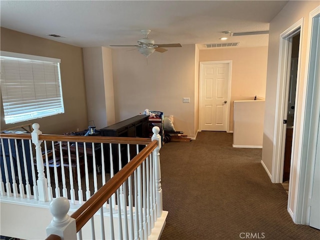 hall with dark colored carpet