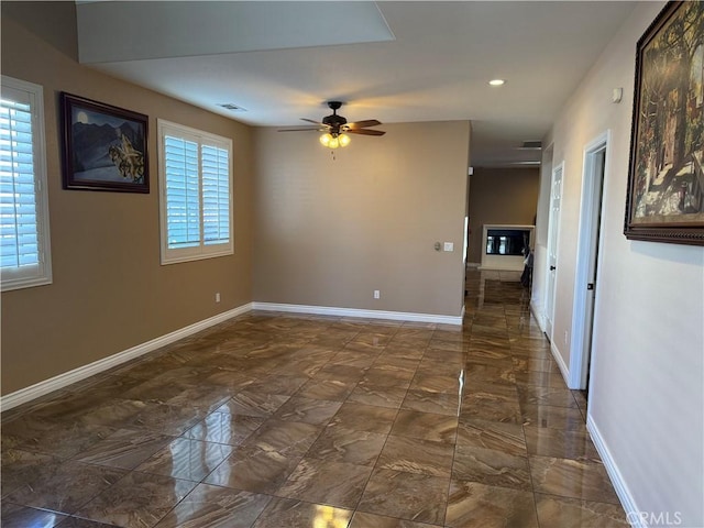 unfurnished room featuring ceiling fan and a wealth of natural light