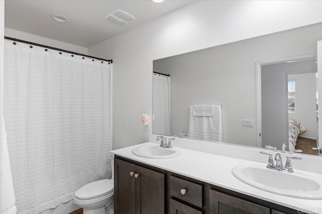 full bathroom with vanity, shower / bath combo with shower curtain, and toilet