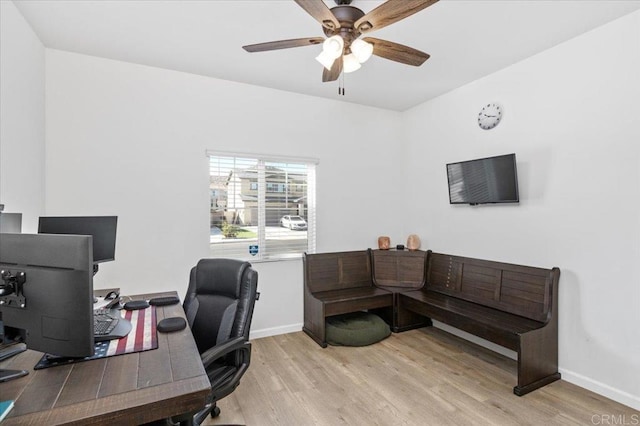 home office with light hardwood / wood-style floors and ceiling fan