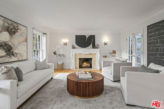 living room with french doors, ornamental molding, a fireplace, and hardwood / wood-style floors