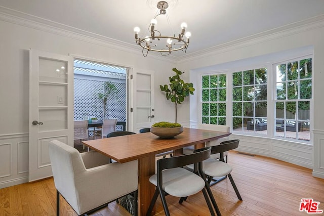 dining room featuring crown molding, a chandelier, and light hardwood / wood-style flooring