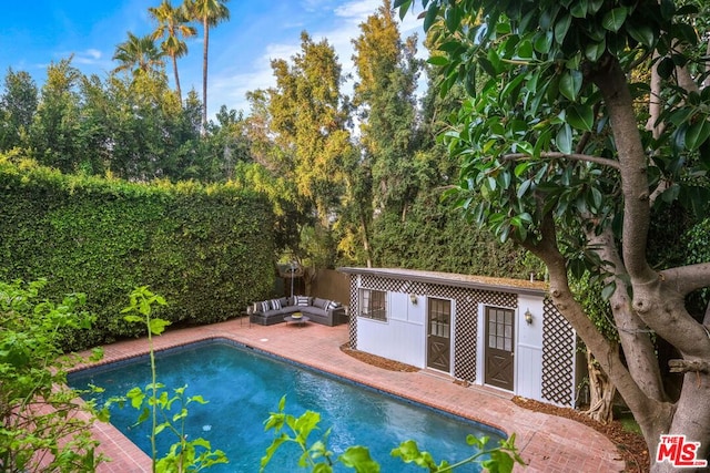 view of swimming pool with an outbuilding and outdoor lounge area